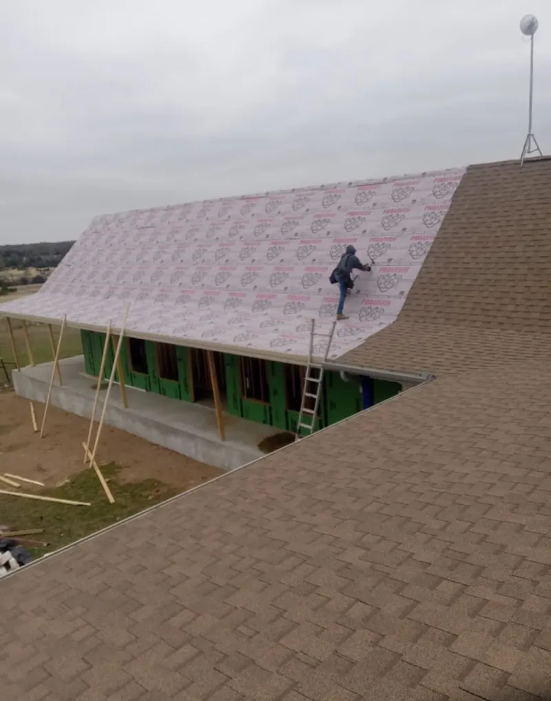 Worker preparing underlayment for a metal roof installation in Loyalsock